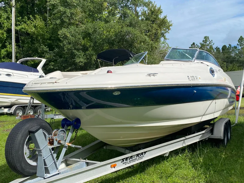 Slide: The Image of 2004 Sea Ray 240 Sundeck boat on trailer, parked on grass. - 2