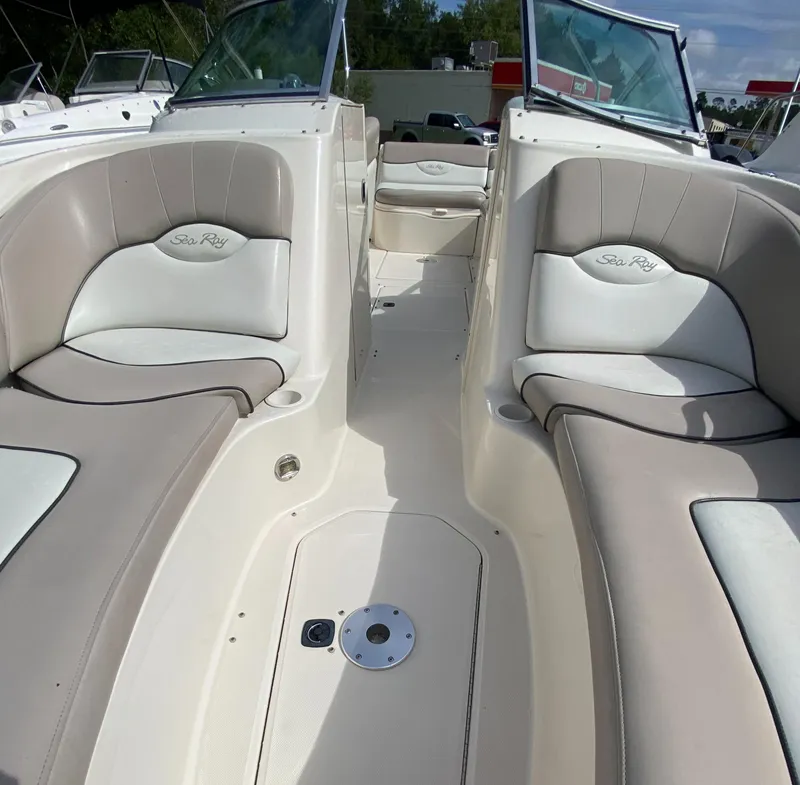 Slide: The Image of 2004 Sea Ray 240 Sundeck interior with beige seating and open deck layout. - 20