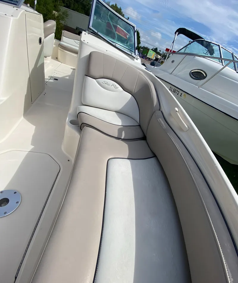Slide: The Image of 2004 Sea Ray 240 Sundeck boat interior with cushioned seating and open deck. - 21