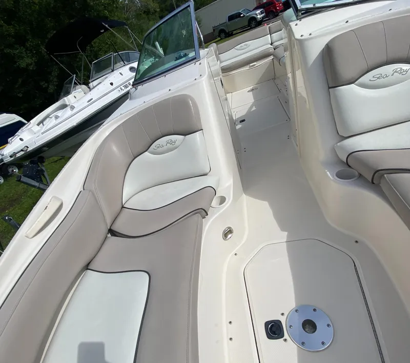 Slide: The Image of 2004 Sea Ray 240 Sundeck interior with beige seating and open deck layout. - 22