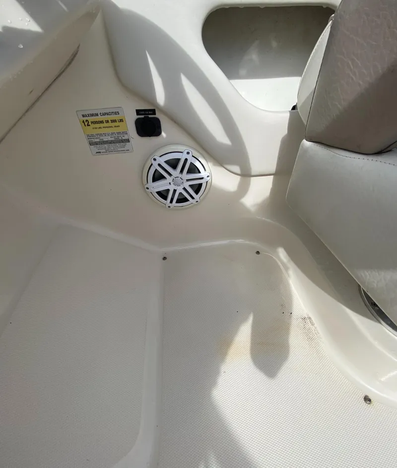 Slide: The Image of 2004 Sea Ray 240 Sundeck interior with speaker and seating area. - 25