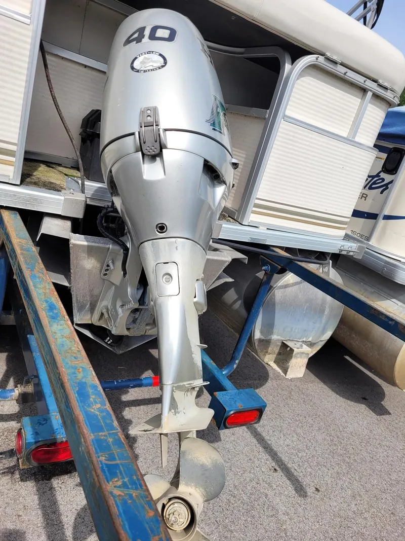 Slide: The Image of Outboard motor on a 2002 Sylvan 820 Mirage pontoon boat, mounted on a trailer. - 10
