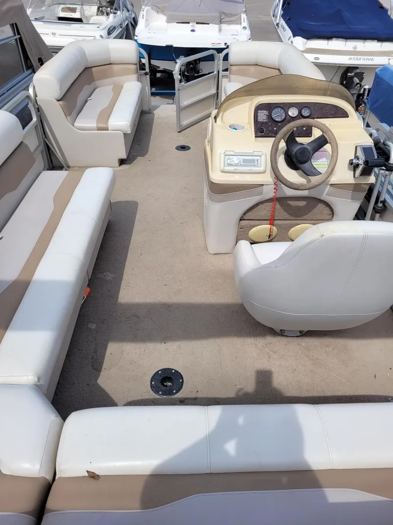 Slide: The Image of Interior of a 2002 Sylvan 820 Mirage boat with beige seating and steering console. - 11