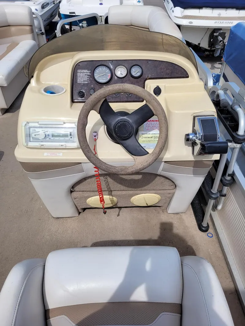 Slide: The Image of Steering console of a 2002 Sylvan 820 Mirage boat with gauges and controls. - 12