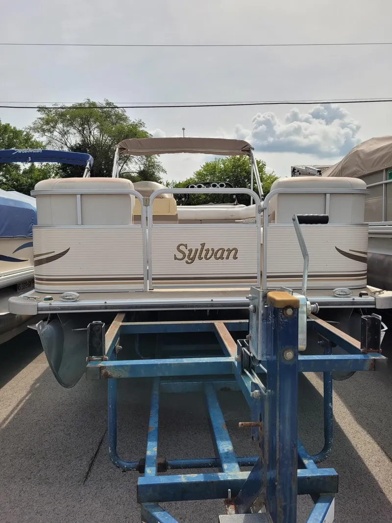 Slide: The Image of 2002 Sylvan 820 Mirage pontoon boat on trailer, parked outdoors. - 3