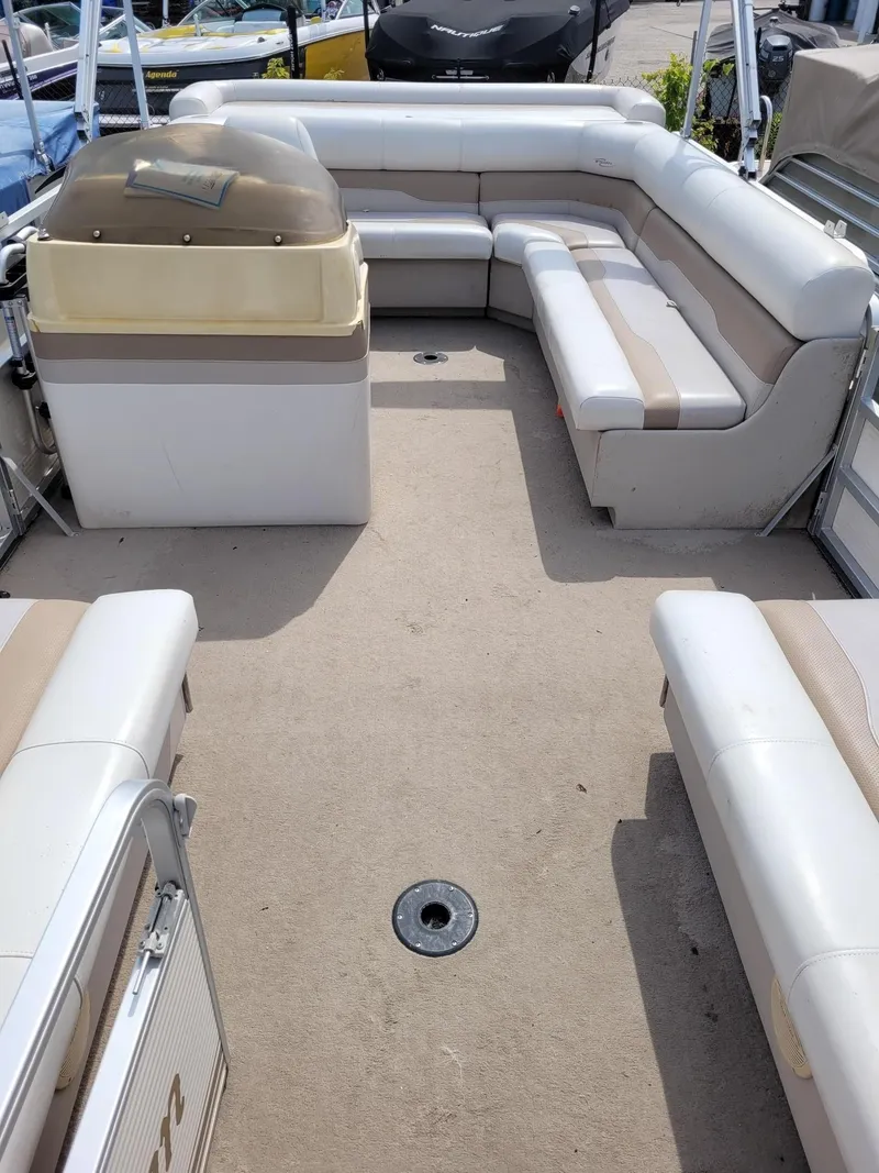Slide: The Image of 2002 Sylvan 820 Mirage pontoon boat interior with beige seating and helm. - 4