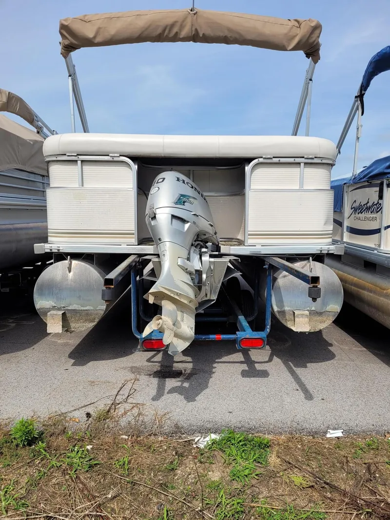 Slide: The Image of 2002 Sylvan 820 Mirage pontoon boat with outboard motor, parked on a trailer. - 9