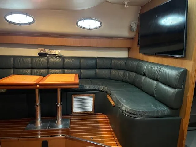Slide: The Image of 1996 Tiara Yachts 40 Express interior with leather seating, wooden table, and mounted TV. - 17