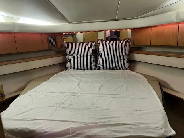 Slide: The Image of 1996 Tiara Yachts 40 Express cabin with striped pillows and cozy bedding. - 20