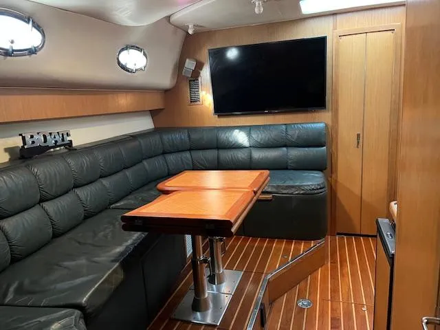 Slide: The Image of 1996 Tiara Yachts 40 Express interior with leather seating, wooden table, and mounted TV. - 21
