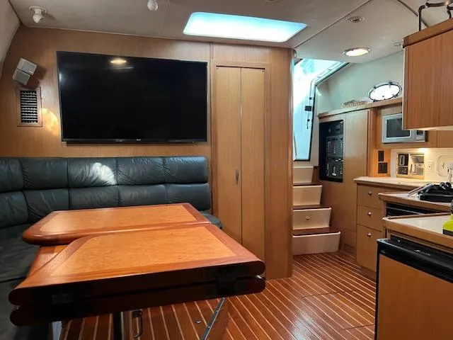 Slide: The Image of Interior of 1996 Tiara Yachts 40 Express, featuring wood flooring, seating, and a kitchenette. - 23