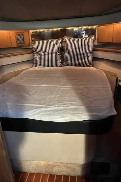 Slide: The Image of Cozy cabin interior of 1996 Tiara Yachts 40 Express with striped pillows and wooden accents. - 24
