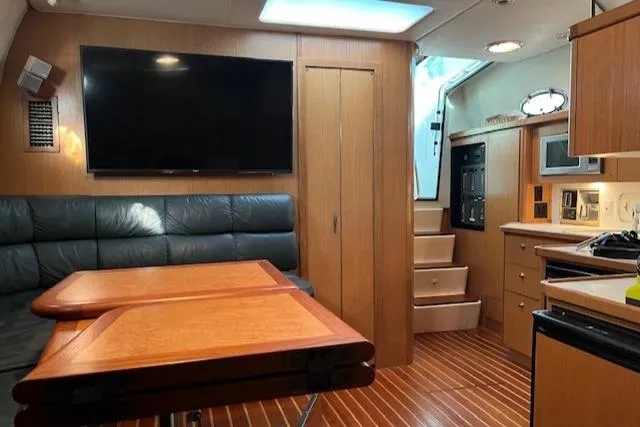 Slide: The Image of 1996 Tiara Yachts 40 Express interior with wood finish, seating, and kitchen area. - 25