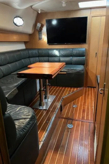 Slide: The Image of 1996 Tiara Yachts 40 Express interior with leather seating, wooden flooring, and mounted TV. - 26