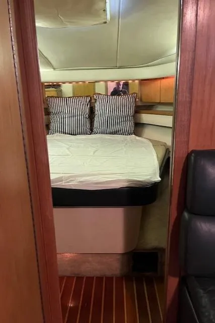 Slide: The Image of 1996 Tiara Yachts 40 Express cabin interior with bed and striped pillows. - 27