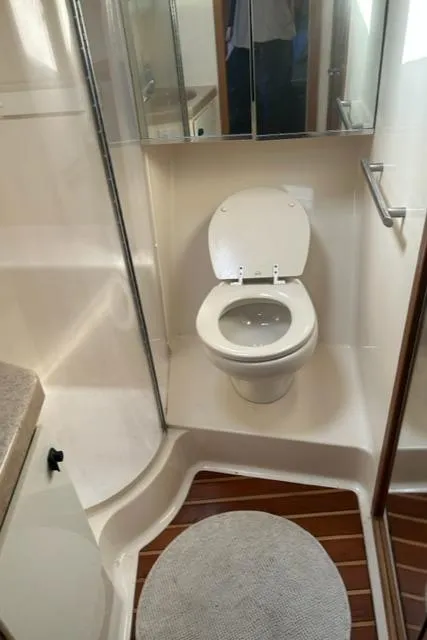 Slide: The Image of 1996 Tiara Yachts 40 Express bathroom with toilet, shower, and wooden flooring. - 28