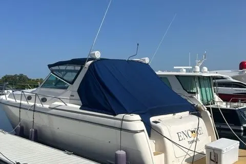 Slide: The Image of 1996 Tiara Yachts 40 Express docked, covered with a blue tarp, sunny day. - 3