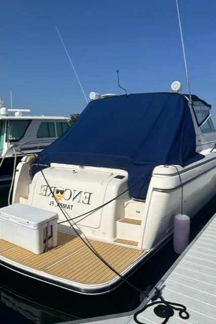 Slide: The Image of 1996 Tiara Yachts 40 Express docked with blue cover and cooler on deck. - 5