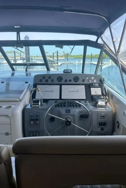 Slide: The Image of 1996 Tiara Yachts 40 Express helm with modern navigation equipment and marina view. - 9