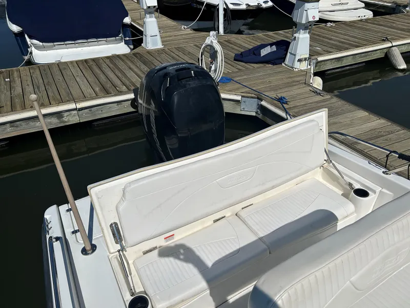 Slide: The Image of 2013 Boston Whaler 230 Dauntless boat docked, featuring rear seating and outboard motor. - 12