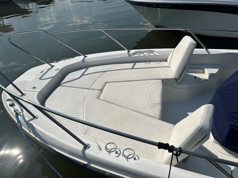 Slide: The Image of 2013 Boston Whaler 230 Dauntless boat with white seating and railings on calm water. - 17