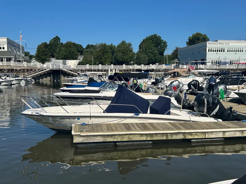 Slide: The Image of 2013 Boston Whaler 230 Dauntless docked at marina on a sunny day. - 2