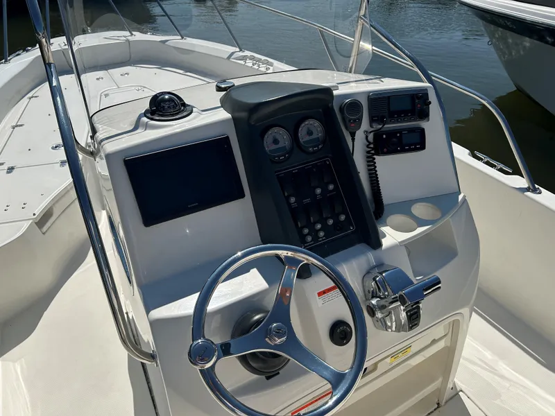 Slide: The Image of 2013 Boston Whaler 230 Dauntless boat console with steering wheel and navigation controls. - 7
