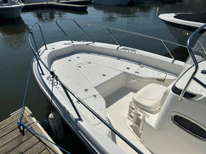 Slide: The Image of 2013 Boston Whaler 230 Dauntless boat docked at marina, featuring spacious deck. - 9