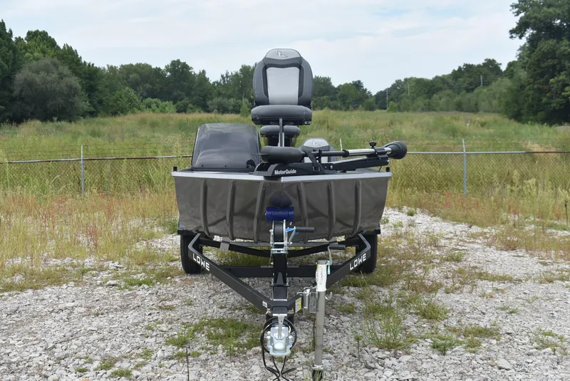 Slide: The Image of 2025 Lowe 16 Skorpion boat on trailer in grassy area. - 2