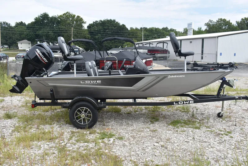 Slide: The Image of 2025 Lowe 16 Skorpion fishing boat on trailer, parked outdoors. - 4