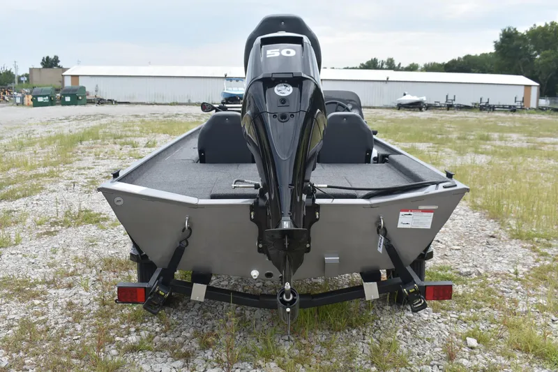 Slide: The Image of 2025 Lowe 16 Skorpion boat with 50 HP motor, rear view on gravel lot. - 5