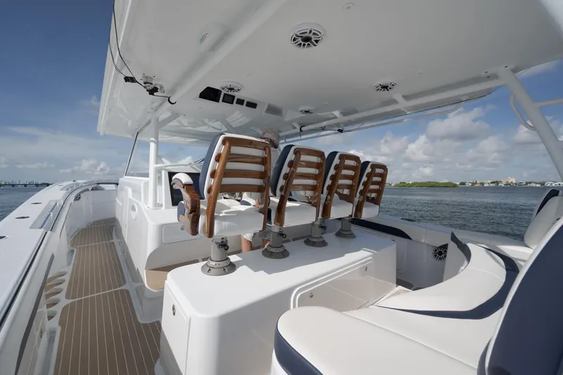 Slide: The Image of 2022 Yellowfin 54 Offshore boat interior with seating, under a clear blue sky. - 11