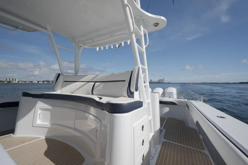 Slide: The Image of 2022 Yellowfin 54 Offshore boat interior with seating, cruising on open water under clear skies. - 12