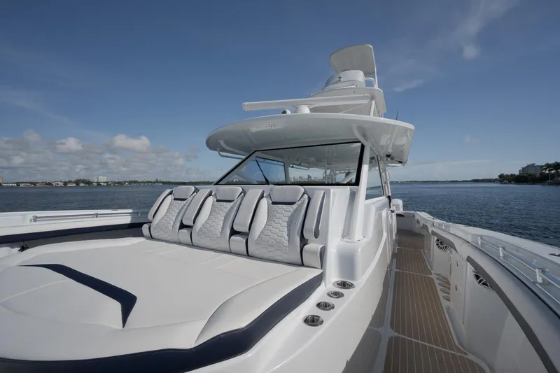 Slide: The Image of 2022 Yellowfin 54 Offshore boat with sleek design, spacious seating, and ocean backdrop. - 14
