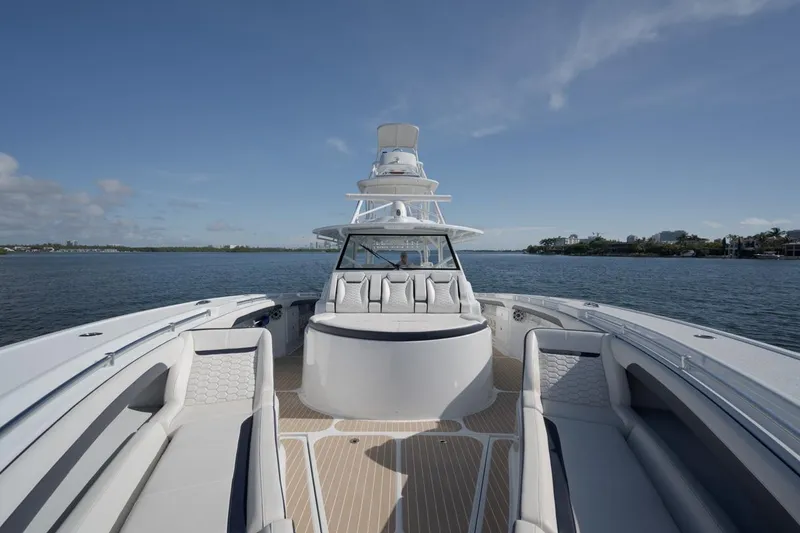 Slide: The Image of 2022 Yellowfin 54 Offshore boat on calm water, showcasing spacious deck and seating. - 15