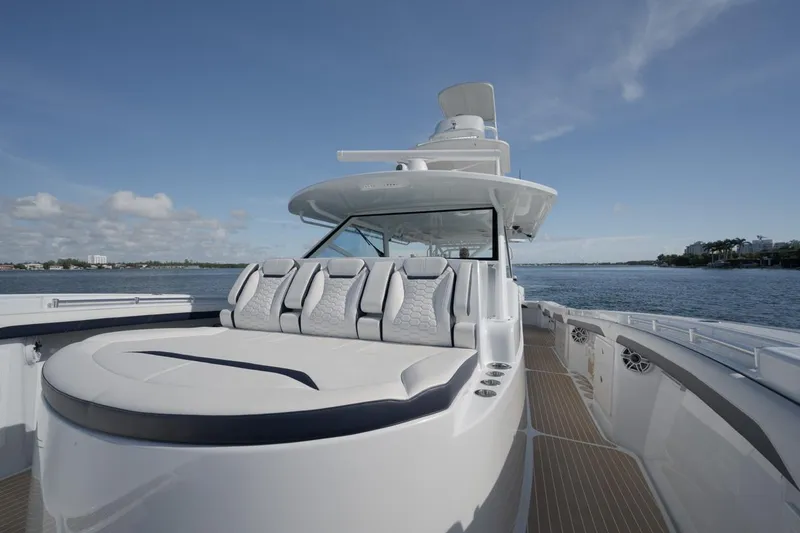 Slide: The Image of 2022 Yellowfin 54 Offshore boat with spacious deck and seating, cruising on calm waters. - 16