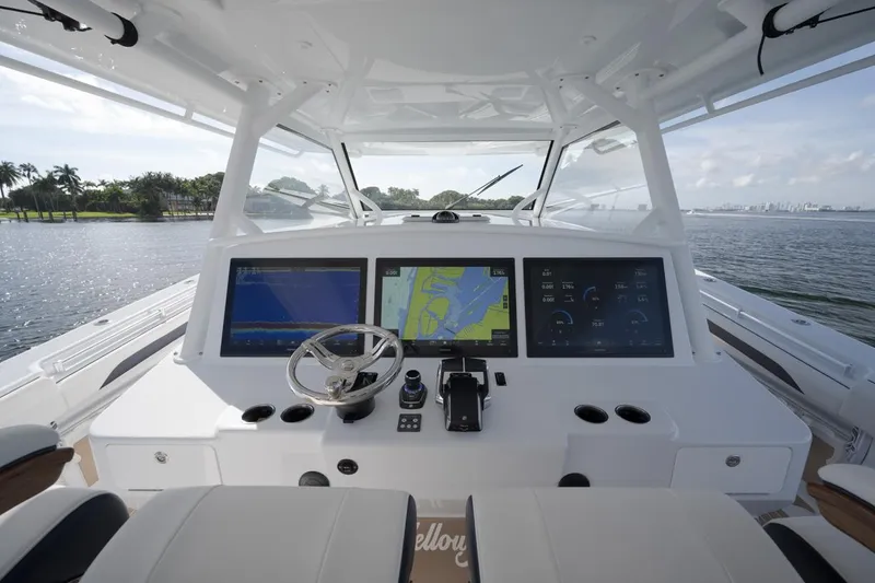 Slide: The Image of 2022 Yellowfin 54 Offshore boat cockpit with advanced navigation screens and steering wheel. - 17