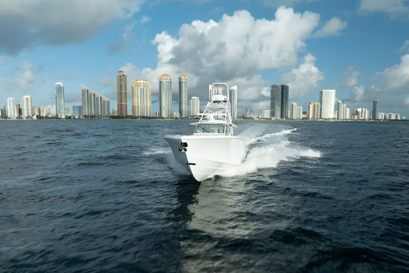 Slide: The Image of 2022 Yellowfin 54 Offshore boat cruising near city skyline under blue sky. - 29