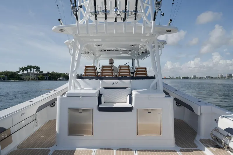 Slide: The Image of 2022 Yellowfin 54 Offshore boat with spacious deck and seating, set against a serene water backdrop. - 9