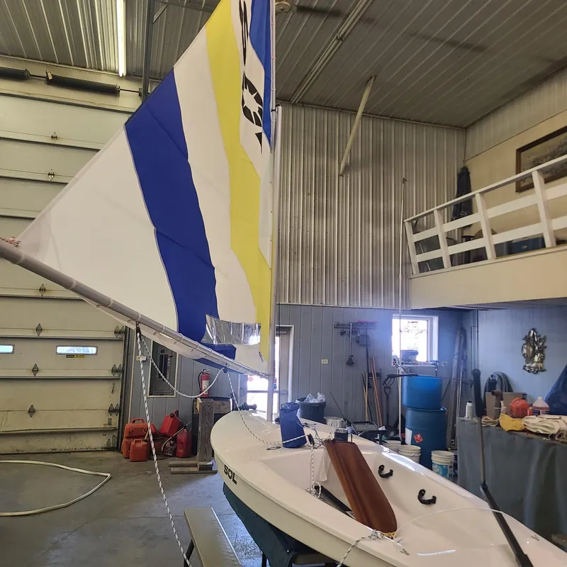 Slide: The Image of 2024 SERO Innovation SOL sailboat with colorful sail in a workshop. - 10