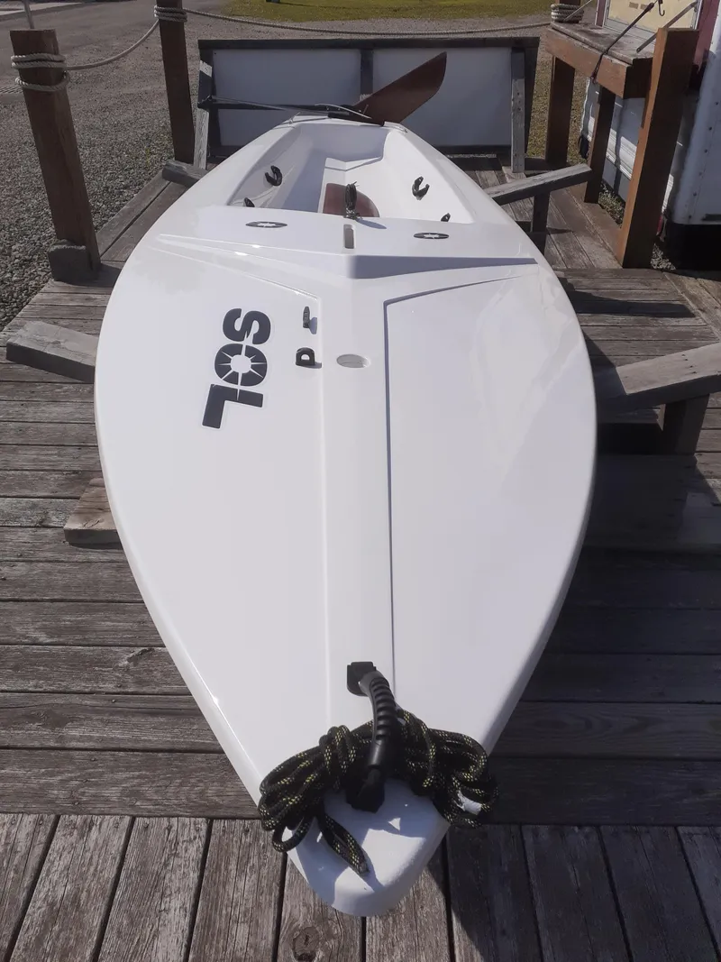 Slide: The Image of 2024 SERO Innovation SOL sailboat on wooden dock, showcasing sleek design and craftsmanship. - 2