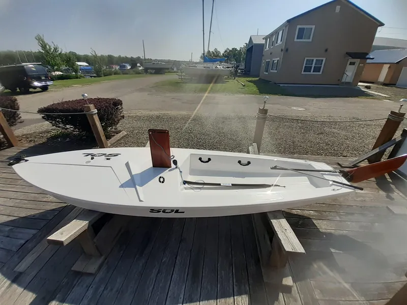 Slide: The Image of 2024 SERO Innovation SOL sailboat on wooden dock, sunny day, residential background. - 5