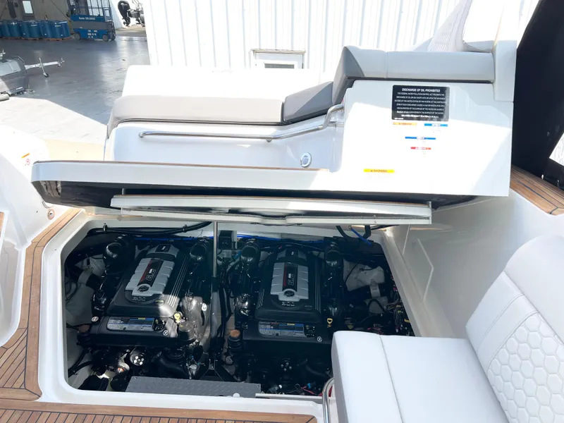Slide: The Image of 2025 Sea Ray Sundancer 320 engine compartment with twin engines, open hatch, and seating area. - 11