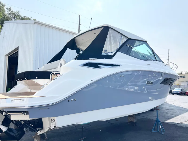 Slide: The Image of 2025 Sea Ray Sundancer 320 yacht in a marina setting, side view. - 2
