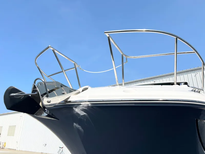 Slide: The Image of 2025 Sea Ray Sundancer 320 boat bow with stainless steel railings under clear blue sky. - 3