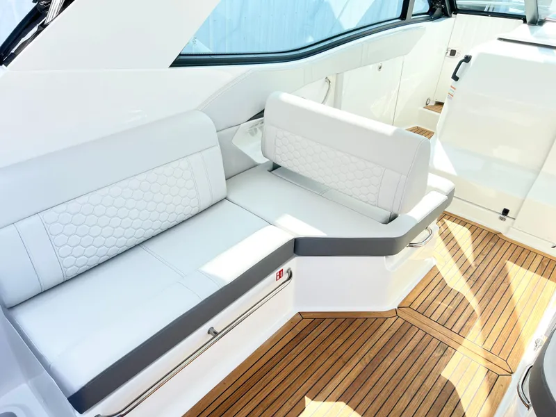 Slide: The Image of 2025 Sea Ray Sundancer 320 interior with white seating and teak flooring. - 6