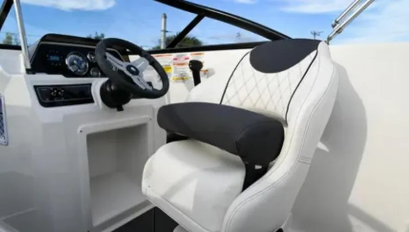 Slide: The Image of 2024 Bayliner DX2000 boat interior with steering wheel and cushioned seat. - 3