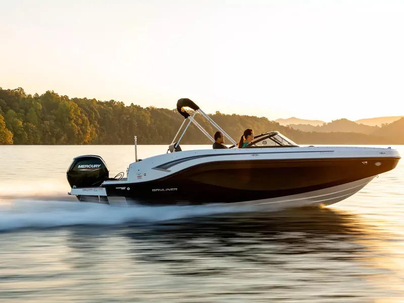 Slide: The Image of 2024 Bayliner DX2000 boat cruising on a serene lake at sunset. - 9