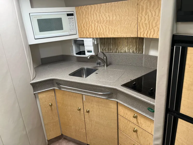 Slide: The Image of 1999 Formula 41 Performance Cruiser kitchen with microwave, sink, and stove. - 17