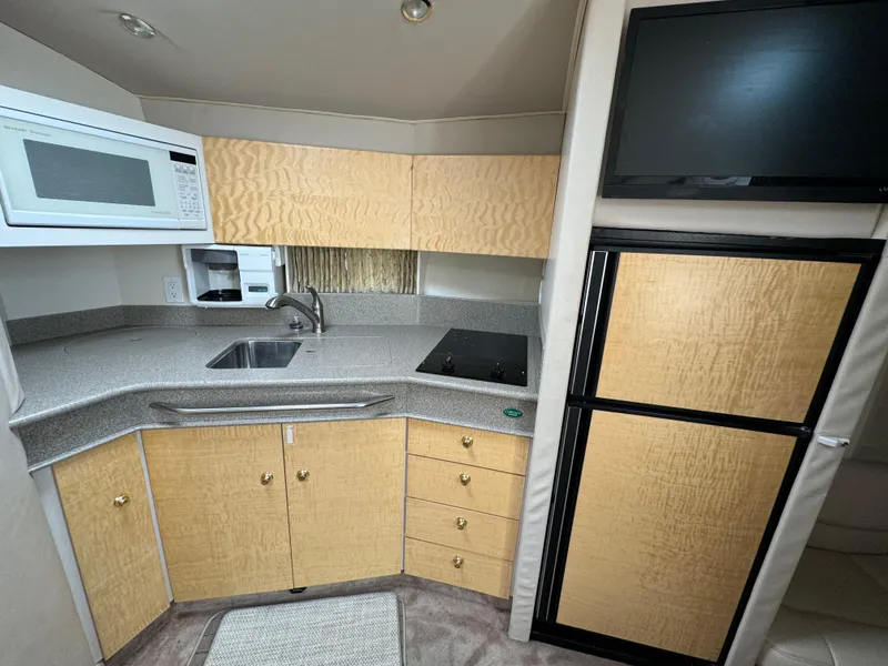 Slide: The Image of 1999 Formula 41 Performance Cruiser kitchen with microwave, sink, stove, and fridge. - 18